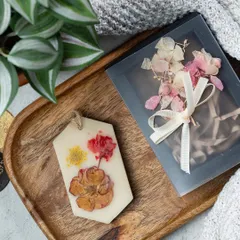A close-up of one of my floral wax tablets. I carefully press real dried flowers into the wax, creating a unique design every time. This one is ready to be gifted in its own special box.