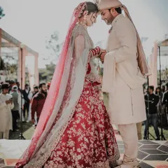 A quiet, intimate moment between the bride and groom during their outdoor wedding ceremony. The backlighting from the sun creates a beautiful, ethereal glow, highlighting this special connection.