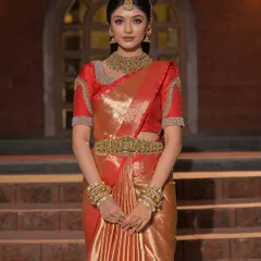 The quintessential South Indian bride in a red and gold Kanjeevaram saree, with traditional temple jewellery and a radiant glow.