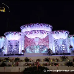 This reception stage showcases our expertise in creating large, intricate structures. The design features a detailed jali-work backdrop, dramatic draping, and massive floral arrangements for a truly royal feel.