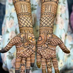 This design beautifully incorporates the couple's wedding rings and their initials into the palm, surrounded by intricate lotus and check patterns.