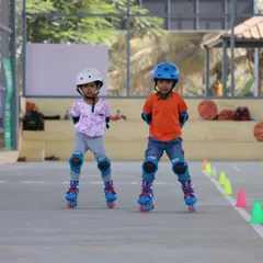 Two young beginners standing tall and finding their balance. This is the very first step in our roller skating lessons, and we make it a fun, no-pressure experience.