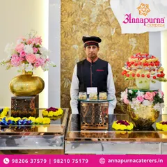 A member of our team standing by a beautifully arranged grazing food table. Our staff ensures that the counters are always well-maintained and ready to serve.
