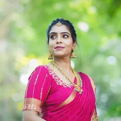 A beautiful outdoor shot of my client ready for a traditional function. Her makeup features a defined eye and a soft mauve lip, which perfectly complements her bright pink silk saree and gold temple jewelry.