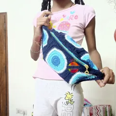 Here is a custom crochet fanny pack I made with a trendy Evil Eye design, modeled by my daughter. These pouches are great for kids to carry their small treasures and can be customized with different colors and themes.