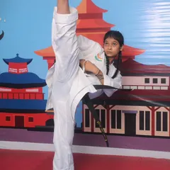 A female black belt student executes a flawless high kick, a testament to her dedication, flexibility, and the high level of skill our students can achieve.