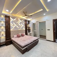 This luxury bedroom is a sanctuary of modern design. The backlit 3D geometric panel serves as a dramatic headboard and a statement wall, while the integrated shelving and tufted bed frame add layers of texture and sophistication.