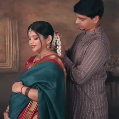 An intimate moment of care and tradition. The partner gently places flowers in her hair, a beautiful gesture captured in our painting-inspired traditional setup.