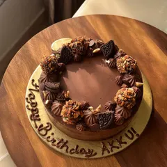 Our Majestic Chocolate Truffle cake. This creation features a 54% dark chocolate cake with hints of coffee, crowned with hand-rolled roasted almond truffles and Oreo pieces.