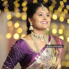This client looks stunning against a bokeh background. She is wearing a unique jewellery set with mint green beads and an antique-finish pendant, perfect for a wedding guest.