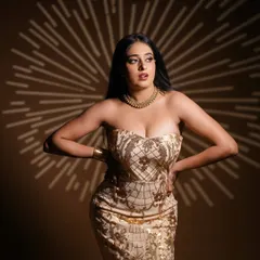Creating a starburst effect with light. This studio shot uses a gobo to project a pattern, adding a layer of visual interest to this glamorous portrait in a gold-sequined dress.