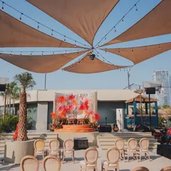 The full view of the rooftop venue, showing the stage, seating, and the canopy of sails that provided shade and style.