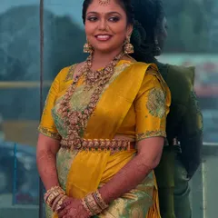 A beautiful portrait of my bride Prithivi against a reflective surface. Her makeup is perfectly balanced, with defined eyes and a lip colour that complements her dusky skin and vibrant saree.