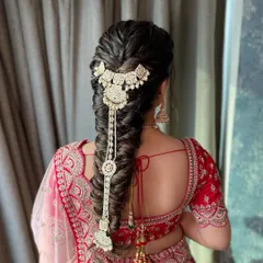 A detailed view of a textured fishtail bridal braid, intricately decorated with a stunning hair accessory.