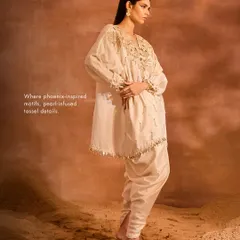 A side view of the ORION Kaftan Set, showing the sumptuous silhouette of the embellished kaftan and the comfortable fit of the solid dhoti pants.