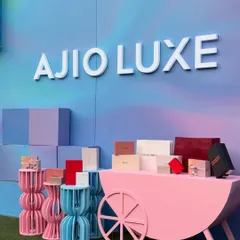 The Ajio Luxe branding stands out against the dreamy, airbrushed background. This setup was designed to attract attention and provide a perfect photo opportunity for guests at the luxury weekend event.
