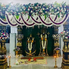 A magnificent floral mandap created for a muhurtham ceremony in front of the deities. The design uses traditional pillars and garlands for a temple-like feel.