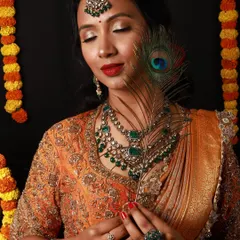 A festive and regal makeover perfect for celebrations like Diwali. This look features warm, shimmering eyes, a classic red lip, and beautiful emerald jewelry to complete the traditional yet glamorous style.