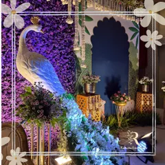 This majestic peacock, with its cascading floral tail against a wall of purple flowers, is an example of how I blend artistry with decor. It's a statement piece that brings a touch of royal elegance and vibrant color to any celebration.