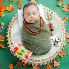 A sleeping newborn wrapped snugly, embodying the peaceful spirit of Shiv. The Rudraksha beads and Trishul add authentic details to this serene and spiritual setup.