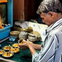A local vendor expertly prepares a plate of chaat. On our food walks, we introduce you to the artisans who have been perfecting these recipes for generations, giving you a true taste of tradition.
