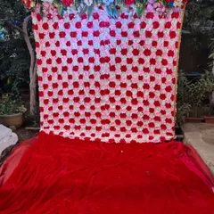 A dense flower wall made of red, pink, and white artificial roses. This makes for a stunning photo backdrop for engagements, birthdays, or any celebration.