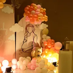 A detailed view of the 'Baby in Bloom' backdrop, featuring a line-art illustration of a mother-to-be, cloud cutouts, and a teddy bear holding a balloon bouquet.