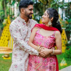A beautiful portrait of a couple during their pre-wedding festivities. The bride's vibrant pink outfit stands out against the traditional yellow decor, showcasing a beautiful color contrast.