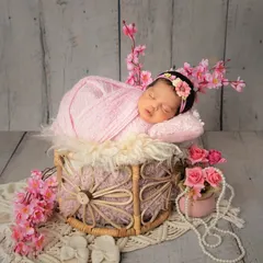 This wider shot shows how I use props like a rustic basket and floral accents to create a complete, beautifully styled scene for your newborn's portrait.