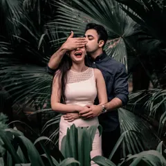 A playful and spontaneous moment in a lush, green setting. The groom-to-be covers her eyes for a surprise kiss, a perfect example of the candid photography I love.