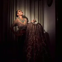 A joyful, candid shot of a bride admiring her wedding lehenga. We love capturing these behind-the-scenes moments of anticipation and happiness before the main ceremony begins.