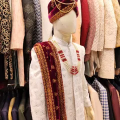 A stunning white sherwani from my 2024 wedding collection, featuring delicate chikankari work. It's paired with a rich velvet maroon stole and pagdi, a combination that is both classic and regal.