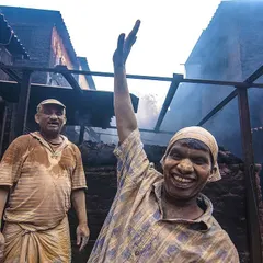 A worker in Kumbharwada shares a moment of lightheartedness amidst a day of hard labor. His smile and wave are a testament to the cheerful resilience I witnessed everywhere in the community.