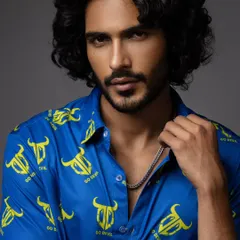 This is a commercial portrait for a clothing brand. The focus is on the model's direct gaze and the vibrant color of the shirt, creating an engaging image for fashion and apparel marketing.
