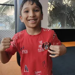 This young fighter proudly shows off his new badge after a great session. We use positive reinforcement to build confidence and motivate our students in every kids' jiu-jitsu class.