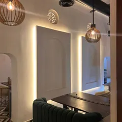 A detail of the restaurant's interior lighting and wall treatment. We used warm, caged pendant lights and backlit wall panels with arched motifs to create an intimate and stylish ambiance.