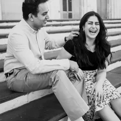 Pure, unadulterated joy captured in a classic black and white frame. This candid shot of the couple laughing on the steps feels authentic and timeless.
