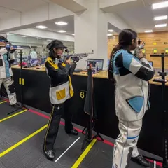 A line of shooters competing at the CISCE National Games and Sports 2023, hosted at our facility. The atmosphere is one of intense focus and sportsmanship.