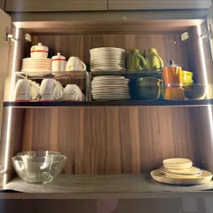 A cabinet dedicated to coffee and tea essentials. We've used risers to stack plates and mugs, leaving space for a moka pot and other accessories.