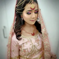 A close-up of a modern bridal look with a focus on dramatic eye makeup using purple and pink tones. Students learn color theory and blending techniques to create custom looks for their clients.