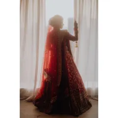 A stunning silhouette of the bride against a window, the light catching the details of her veil and lehenga. A truly artistic bridal portrait.
