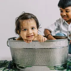 A splash session is even more fun with a big brother to help. This sweet moment of sibling interaction is just priceless.