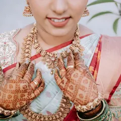 A close-up showcasing the bride's traditional gold necklace and intricate mehndi design. These are the beautiful details that tell a cultural story.