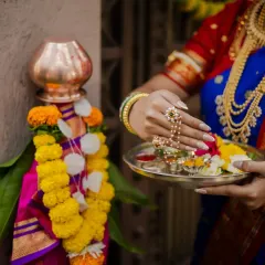 A close-up shot focusing on the details of the Gudi Padwa ritual. This image highlights the model's hands, adorned with beautiful jewelry, as she offers flowers to the Gudi, symbolizing new beginnings.