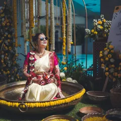 A unique Haldi setup, with the bride looking cool in sunglasses while seated in a large decorative urli bowl. I always look for creative ways to photograph traditional ceremonies.