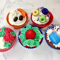 A collection of five different cupcake soap designs, from fruity loops to elegant roses, made using cold process soap and soap frosting.