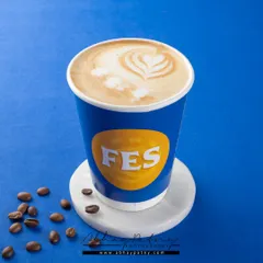 A simple, bold shot of a coffee cup against a solid blue background. This minimalist style makes the brand logo and the latte art the main focus, creating a strong brand statement.