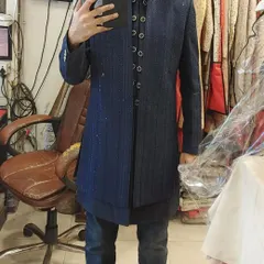 A client trying on a navy blue Indo-Western jacket with subtle glitter stripes. It's a great modern option that pairs well with jeans or formal trousers.