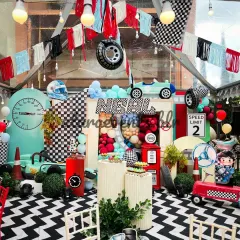 For high-energy celebrations, I design detailed themes like this race car party. The setup includes a custom-floored track, a full stage with a gas station prop, and themed seating to make every little guest feel like a champion.