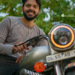 This portrait combines a smiling subject with a focus on the custom headlight of his Royal Enfield. It's a great way to create a lifestyle photo that highlights both the person and their passion.